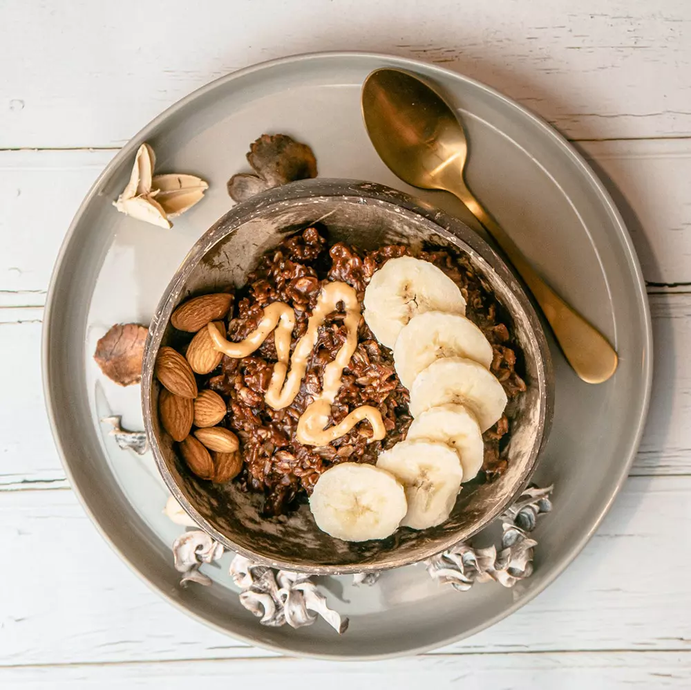 Haferflocken mit Kakao, Banane, Erdnussbutter und Mandeln